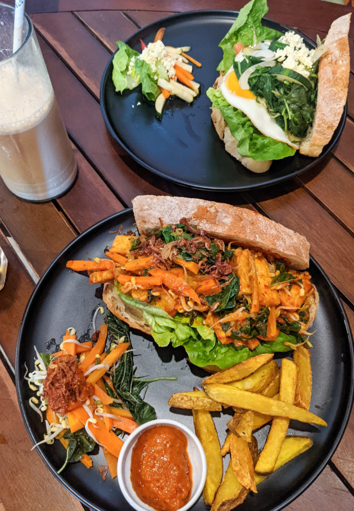 The best food in Gili T - tofu sandwich with fries on a wooden table.